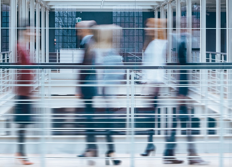 wnętrze budynku biurowego z szybko przemieszczającymi się osobami